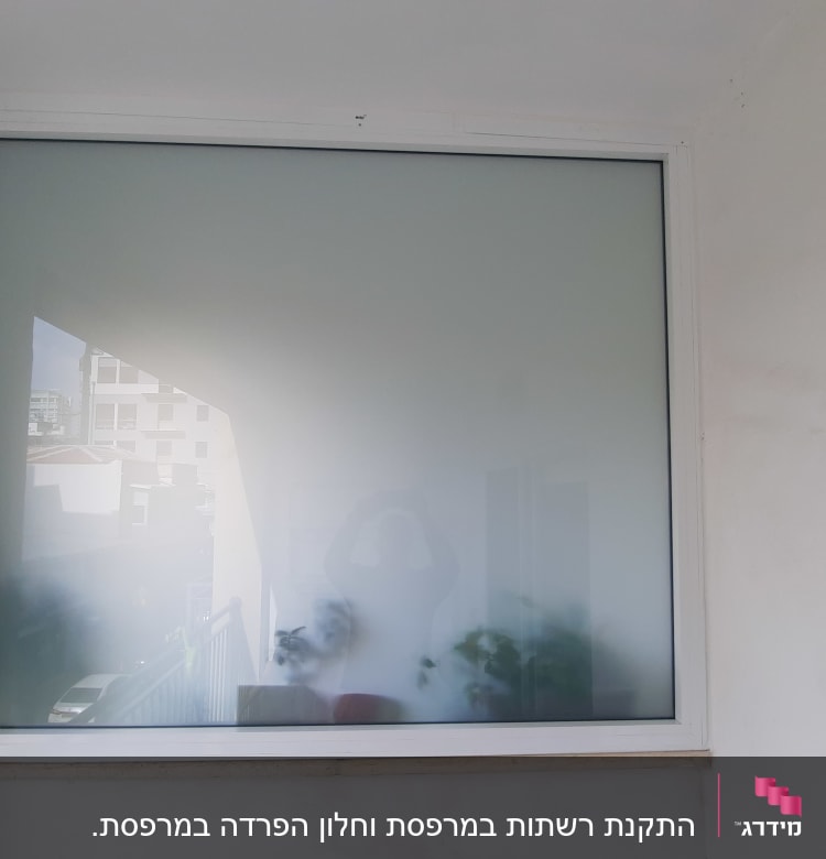 חלון עם מסגרת אלומיניום על קיר לבן